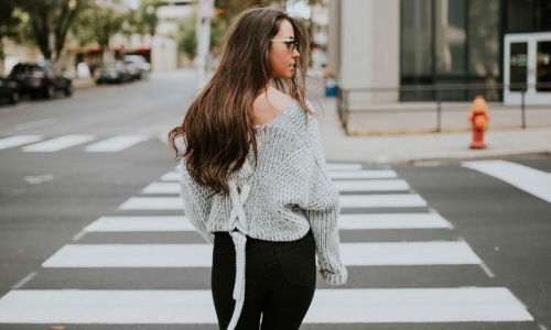 Close to the center of everything a person walking in a crosswalk
